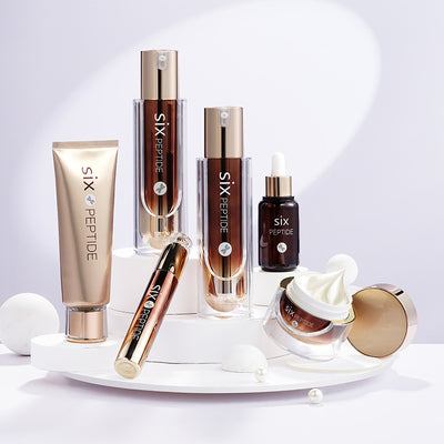 A collection of skin care products displayed on a white surface, including moisturizers, serums, and creams, with branding elements visible.